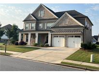 Beautiful two-story brick home featuring an attached two car garage, landscaped front yard and covered front porch at 4405 Croftshire Pl, Cumming, GA 30040