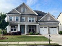 Beautiful two-story brick home featuring an attached two car garage and manicured front yard at 4405 Croftshire Pl, Cumming, GA 30040