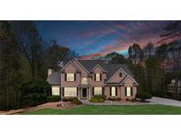 Stunning brick home featuring manicured lawn, tasteful landscaping, and a grand entrance at 2830 Willow Hill Ct, Cumming, GA 30040
