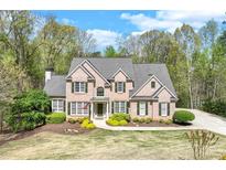 Charming brick home with manicured lawn, lush landscaping, and a welcoming entrance at 2830 Willow Hill Ct, Cumming, GA 30040