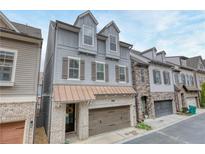 Charming townhome showcasing craftsman details, gray siding, brick accents, and a welcoming two-car garage at 433 Cranleigh Se Rdg, Smyrna, GA 30080