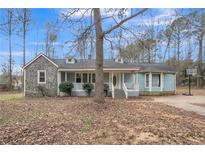 Charming single-story home with stone accents, a welcoming front porch, and a basketball hoop in the driveway at 265 Winding Stream Trl, Hampton, GA 30228