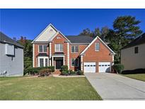 Charming brick two-story home with well-manicured lawn and a two-car garage on a sunny day at 1721 Telfair Chase Way, Lawrenceville, GA 30043