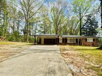 Charming single-story brick home with a covered carport and a long driveway at 3947 Pleasant Trl, Doraville, GA 30340