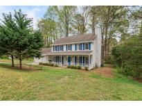 Charming two-story home featuring a welcoming front porch and a well-maintained landscaped lawn at 9992 Neuchatel Cres, Jonesboro, GA 30238