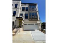Charming three-story home with a two-car garage and brick and siding facade at 1105 Rivard Nw Cir, Atlanta, GA 30318