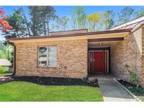 Charming single story brick home with a manicured lawn and inviting red front door at 1603 Circlestone Dr, Stone Mountain, GA 30088