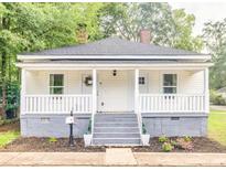 Charming single-story home with a cozy front porch, fresh landscaping, and a welcoming entrance at 13 E Palmetto St, Porterdale, GA 30014