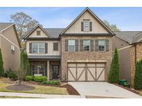 Charming two-story home with brick facade, complemented by a well-manicured lawn and a two-car garage at 1895 Weston Ln, Tucker, GA 30084
