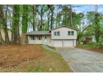 Charming home features a front yard with mature trees and a two-car garage, offering both curb appeal and functionality at 3309 Poplar Dr, Lawrenceville, GA 30044