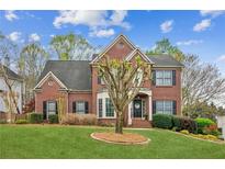 Charming two-story brick home with a well-manicured lawn and mature landscaping at 4155 Summit Gate Dr, Suwanee, GA 30024