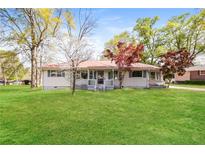 Charming single-story home with a metal roof, inviting front porch, and a lush green lawn at 5798 Salem Rd, Covington, GA 30016