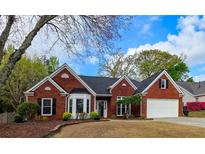Charming one-story brick home featuring a well-manicured lawn, dormer windows, and attached two car garage at 2004 Westover Nw Ln, Kennesaw, GA 30152