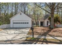 Charming single-story home featuring a well-manicured front yard, attached garage, and inviting entrance at 5882 Riverside Walk Dr, Sugar Hill, GA 30518