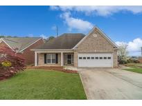 Charming brick home featuring an attached garage and well-maintained front lawn at 1170 Livery Cir, Lawrenceville, GA 30046