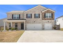 Beautiful two-story home with brick and stone accents, a two-car garage, and a well-manicured lawn at 2804 Torunn Ct, Atlanta, GA 30331