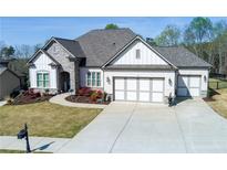 Beautiful single-Gathering home featuring a well-manicured lawn, stone accents, and a three-car garage at 432 Horizon Trl, Canton, GA 30114