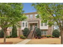 Brick townhouse with landscaped front yard and inviting staircase at 4934 Wyeth Way, Johns Creek, GA 30022