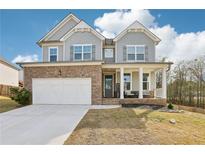Charming two-story home featuring stone accents, inviting front porch, and a well-maintained front yard at 139 Rushing View Gln, Dallas, GA 30157
