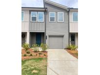 Modern townhome with a gray exterior, manicured landscaping, and a one-car garage at 1516 Parks Edge Nw Ln, Atlanta, GA 30318
