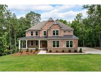 Beautiful two-story brick home with a welcoming front porch and a well-manicured lawn surrounded by lush trees at 7580 Sunridge Ln, Douglasville, GA 30135
