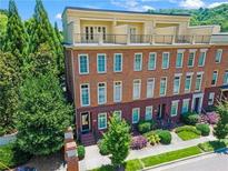 Brick townhome with a rooftop patio overlooking trees and a professionally landscaped lawn at 900 River Vista Dr, Atlanta, GA 30339