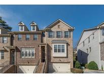 Beautiful brick townhome with two-car garage, covered entry, and multiple windows at 1384 Doublegate Dr, Brookhaven, GA 30319