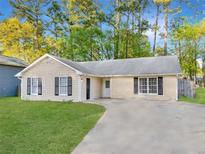 Charming single-story home featuring a well-manicured lawn and a long driveway at 2199 Summertown Dr, Norcross, GA 30071