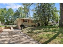 Charming split-level home with a driveway leading to a garage and a grassy front yard at 2062 Cezar Nw Dr, Kennesaw, GA 30152