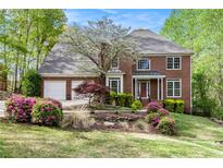 Charming brick two-story home with manicured front yard and mature landscaping at 5145 Southlake Dr, Alpharetta, GA 30005