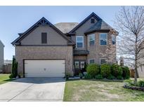 Charming two-story home with a well-manicured lawn, brick facade, and inviting double-door entryway at 4685 Orchard View Way, Cumming, GA 30028