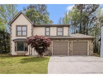 Charming home with a two-car garage and stone accents, complemented by a well-manicured lawn at 1577 Linksview Close, Stone Mountain, GA 30088