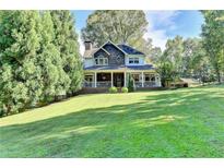 Charming two-story home with a welcoming front porch, manicured lawn, and mature trees at 2962 Norman Cir, Duluth, GA 30096