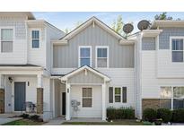 Charming townhouse featuring a modern white and gray exterior with a welcoming front porch at 4457 Watson Ridge Dr, Stone Mountain, GA 30083