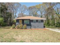 Charming single-story home featuring a cozy front porch and landscaped yard at 5085 Lake Dr, Forest Park, GA 30297