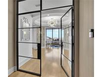 Elegant entryway with steel and glass doors leading to a formal living room with stunning chandelier at 2828 Peachtree Nw Rd # 3100, Atlanta, GA 30305