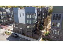 Modern townhome exterior featuring brick facade, gray accents, multiple windows and attached garages at 379 Pratt Se Dr # 408, Atlanta, GA 30315