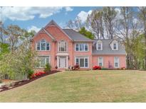 Charming two-story brick home with a manicured lawn and beautiful landscaping in a desirable neighborhood at 1343 Riverview Run Ln, Suwanee, GA 30024