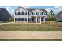 Charming two-story home with blue shutters, covered porch, and well-maintained lawn at 156 Marchmont Dr, Locust Grove, GA 30248