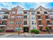 Beautiful multi-story condo building featuring brick and beige siding, balconies, and landscaped grounds at 1850 Cotillion Dr # 2221, Atlanta, GA 30338