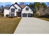 Charming two-story home featuring a well-maintained lawn, a long concrete driveway, and a two-car garage at 3286 Sir Henry St, Atlanta, GA 30344