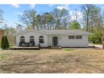 Charming single-story brick home featuring arched windows and a cozy front porch at 5906 Rosie Se Ln, Mableton, GA 30126