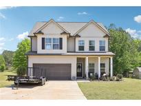 Beautiful two-story home featuring a spacious lawn, attached garage, and a charming front porch perfect for outdoor relaxation at 103 Cottage Way, Euharlee, GA 30145