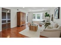 Bright living room with hardwood floors, a bay window, and a decorative armoire at 6851 Roswell Rd # D-6, Atlanta, GA 30328