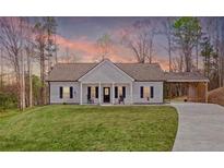 Charming single-story home with a welcoming front porch, well-manicured lawn, and attached carport at 121 Tricias Way, Temple, GA 30179