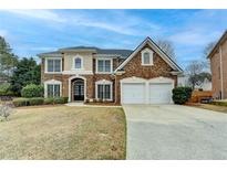 Charming two-story brick home with a well-manicured lawn and two-car garage at 2723 Ivy Bluff Ct, Buford, GA 30519