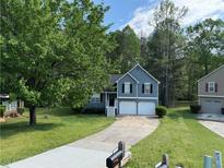 Charming two-story home featuring a two-car garage and a well-maintained front yard with mature trees at 3304 Mooring Dr, Powder Springs, GA 30127