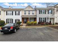 Traditional townhome showcasing a well-kept front yard, a driveway and black shutters at 10900 Wittenridge Dr # D5, Alpharetta, GA 30022