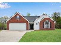 Charming single-story brick and white home featuring a well-manicured lawn and two-car garage at 111 Shenandoah Ct, Hiram, GA 30141