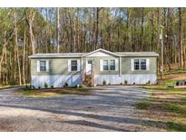 Charming single-story home with a lush, wooded backdrop and well-maintained front yard at 2466 Monroe Jersey Rd, Covington, GA 30014
